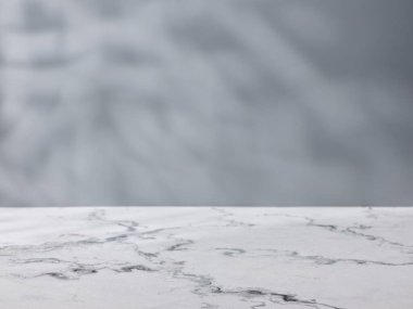 Beton bir duvarın arkasındaki mermer masa.