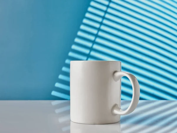 Fehér Csésze Asztalon Kék Háttér — Stock Fotó