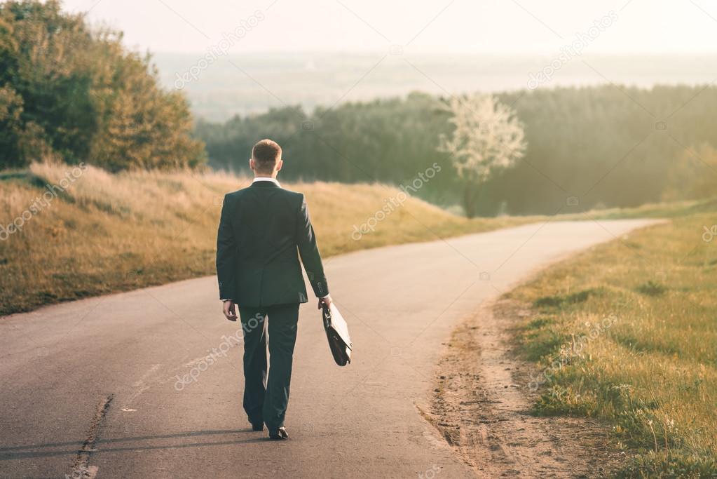 man walking on country road.