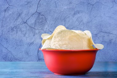 Ahşap masa üzerinde kase cips