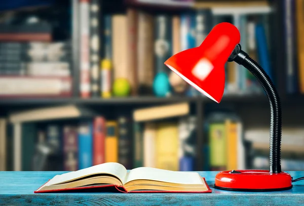 Livre et lampe sur la table dans la bibliothèque — Photo