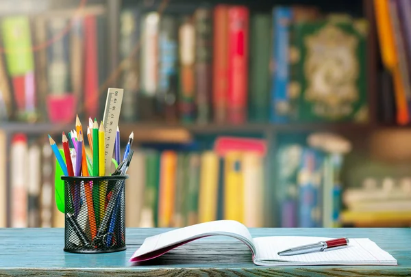 Kopie-boek, pen en potloden op tafel — Stockfoto