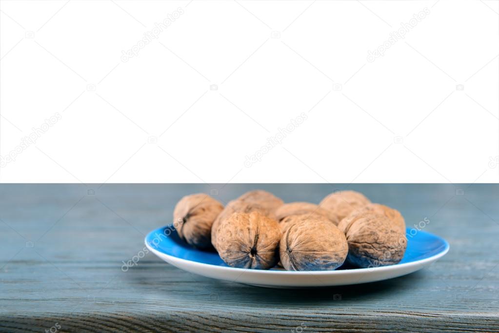 Walnuts in plate on wooden table