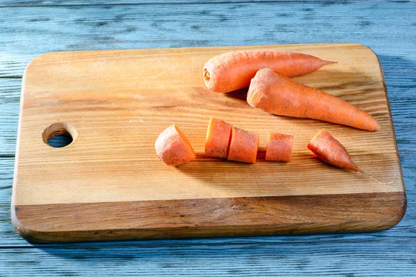 Cutting carrots on board — Stock Photo, Image