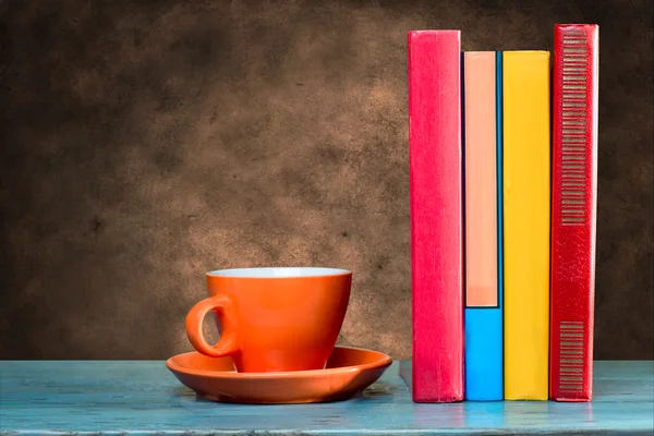 Cup och böcker på bord — Stockfoto