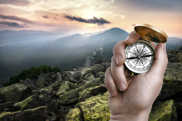 Compass in hand over mountains — Stock Photo, Image