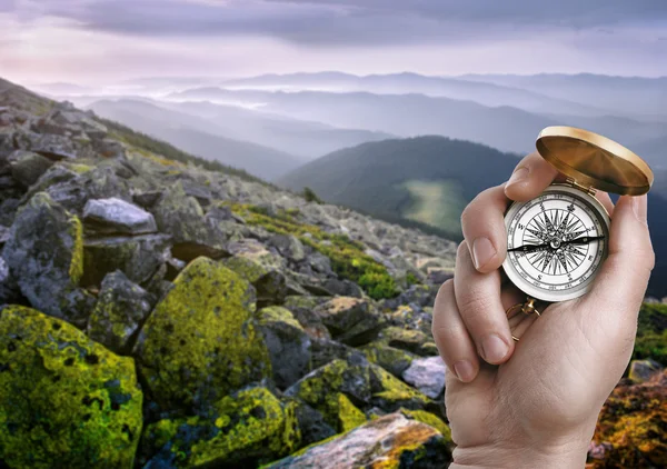Hand holding compass in mountains — Stock Photo, Image