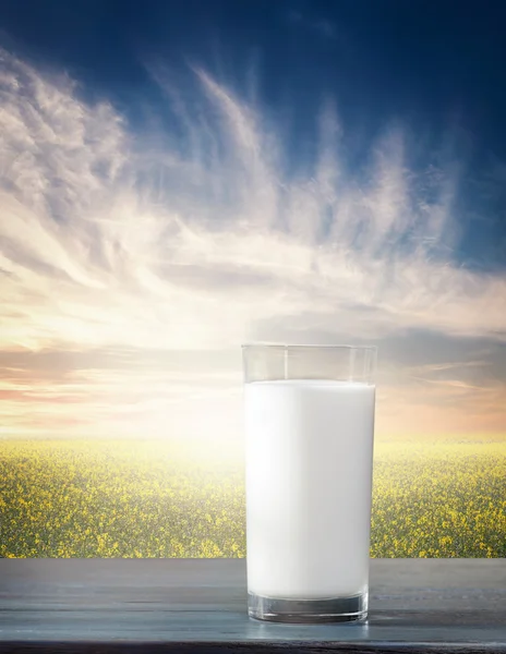 Glass of milk against nature landscape — Stock Photo, Image