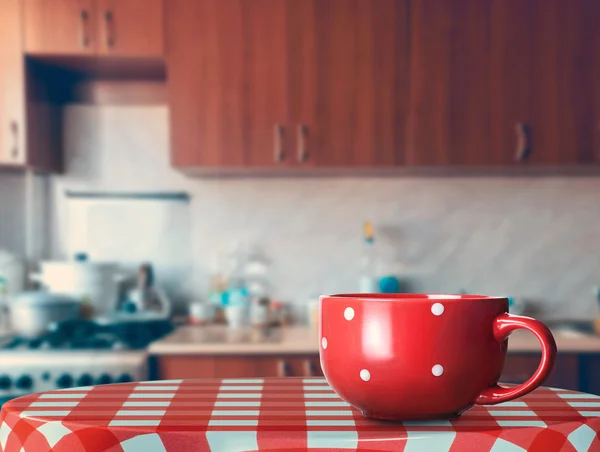 Большой красный стакан на кухонном столе — стоковое фото