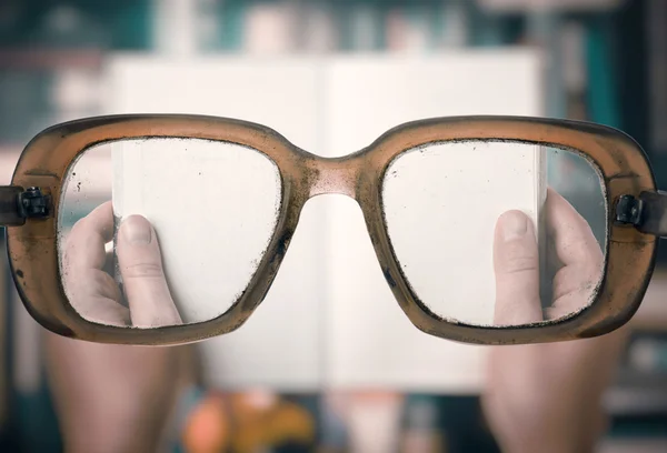 Lezen van boek op zoek door glazen — Stockfoto