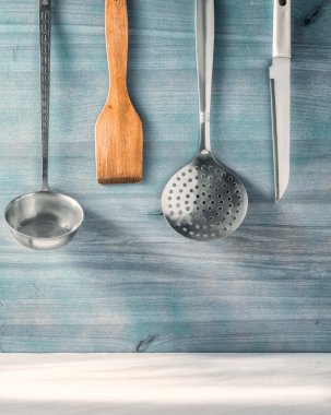 Ahşap arka plan üzerinde asılı mutfak eşyaları