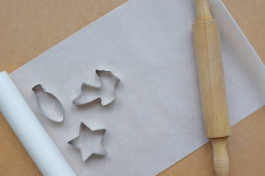 Kurabiye kalıpları, zencefilli çörekler ahşap bir arka planda yatıyor..