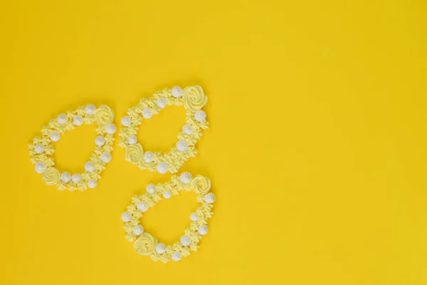 Easter meringue decor. Egg shape on yellow backgrounds.