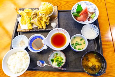 Lezzetli Nigiri suşisi ve Tempura dürümleriyle ahşap tabağın en üst görüntüsü..