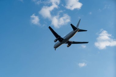 Güzel gün batımı ışığında dramatik bulutların üzerinde uçan ticari uçak. Seyahat kavramı.