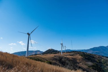 Rüzgâr türbinleri güzel güneşli yaz mevsiminde, sonbahar mevsiminde, dağ sapında. Yeşil ekolojik enerji üretimi. Rüzgar tarlası eko alanı.