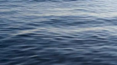 Gün batımında gökyüzü ve bulutların arasında güneş olan sakin bir deniz. Meditasyon okyanusu ve gökyüzü arka planı. Huzurlu deniz manzarası. Suyun üzerinde ufuk..