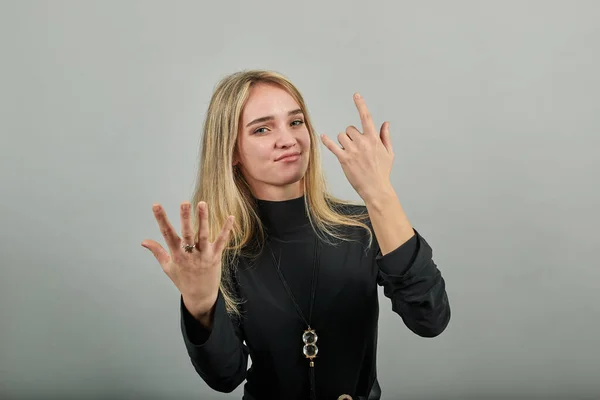 Giving rock and roll sign, showing symbol of the horns, language gestures