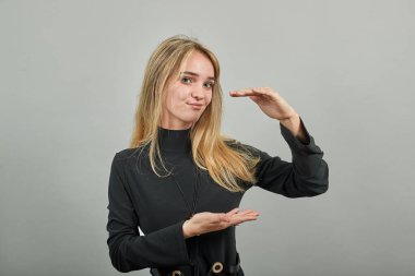 İki eli olan büyük bir nesne, şaşkınlıktan nefesi kesiliyor, avuçlarını önünde tutuyor.