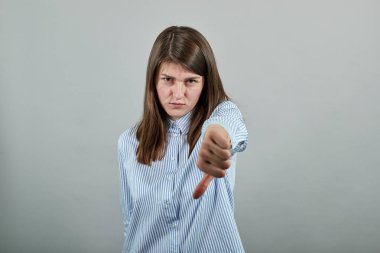 İnsan elinin baş parmağı aşağıda, tamam işareti yok, kızgın yüz, olumsuz jest sevmeme