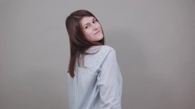 Gülümseyen genç model saçlarını tarıyor, moda pozları veriyor, elleri iplik gibi..