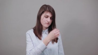 Burnunu eliyle kapatarak pis kokan, izole edilmiş, elleri ters dönmüş bir şey gösteriyor.