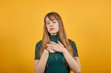 Kalbe yakın el ele tutuşmak, kollarını göğsüne bastırmak, minnettarlığını göstermek, yardım etmek.