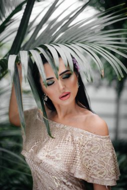 Genç ve güzel bir esmer, sık orman ve yağmur ormanları arasında poz veriyor. Spa