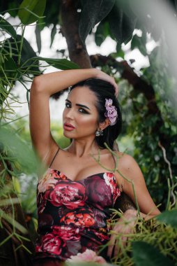 Genç ve güzel bir esmer, sık orman ve yağmur ormanları arasında poz veriyor. Spa