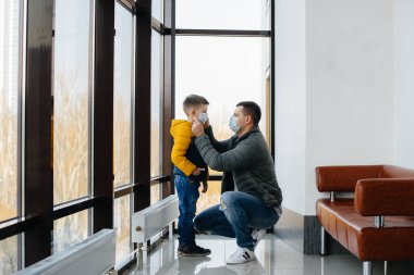 Karantina sırasında çocuklu bir baba maske takıyor. Salgın, koronavirüs.