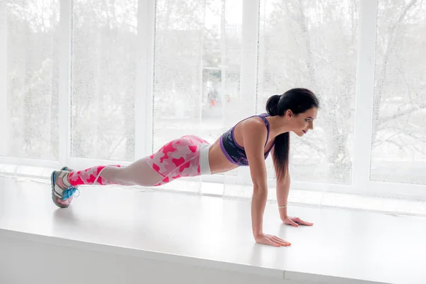 Chica Joven Atlética Realiza Ejercicios Estudio Sobre Fondo Claro Fitness —  Fotos de Stock