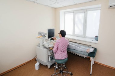 Hamile bir kız klinikte karnının ultrasonuna giriyor. Tıbbi muayene