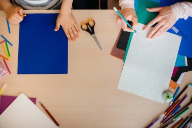 Ödevimi yaptığım masaüstüne yakın çekim. Bir okul çocuğuyla annesi. Çalış