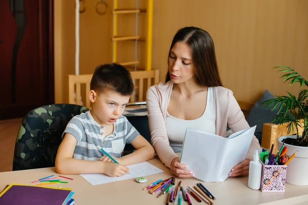 Una Giovane Madre Sta Facendo Compiti Con Suo Figlio Casa — Foto Stock