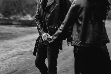 Yakın planda el ele tutuşan sevgi dolu bir çift. Siyah-beyaz