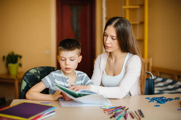 Young Mother Doing Homework Her Son Home Parents Training — Stock Photo, Image