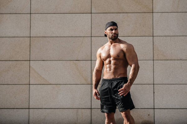 Сексуальный мужчина позирует топлесс под жарким солнцем. Фитнес. Стиль жизни