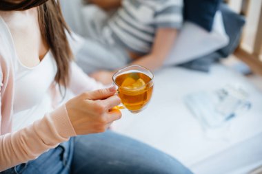 Anne hastalık ve virüs sırasında bebeğine limonlu sıcak çay verir. İlaç ve bakım