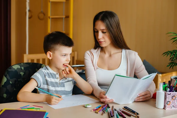 Una Giovane Madre Sta Facendo Compiti Con Suo Figlio Casa — Foto Stock