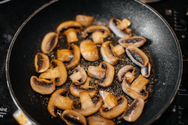 İnce dilimlenmiş taze çiğ mantarlar yakın plan çekimde kızartılır. Sağlıklı beslenme
