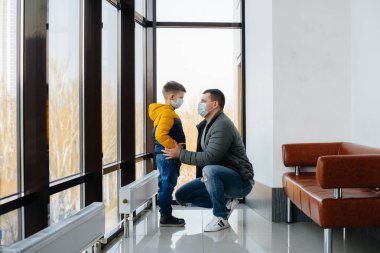 Karantina sırasında çocuklu bir baba maske takıyor. Salgın, koronavirüs.