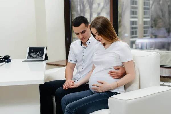 A young couple at a gynecologist\'s consultation after an ultrasound. Pregnancy, and health care