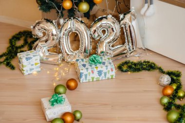 Sevimli gülümseyen bebek, Noel ağacının altında yatıyor ve hediyelerle oynuyor. Noel ve Yeni Yıl kutlamaları