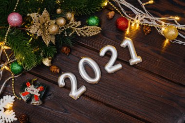 Ahşap Noel arkaplanı şenlikli dekorlar, fenerler, kar taneleri ve Noel ağacının dallarıyla süslenmiş. Noel kartı. Kış tatili. Mutlu yıllar..