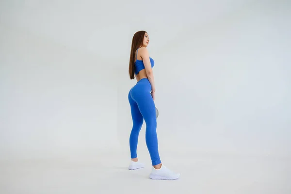Sexy Joven Realiza Ejercicios Con Peso Chándal Azul Sobre Fondo —  Fotos de Stock