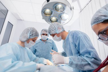 Modern bir ameliyathane, yakın çekim, acil kurtarma ve hastanın canlandırılması. İlaç ve ameliyat.