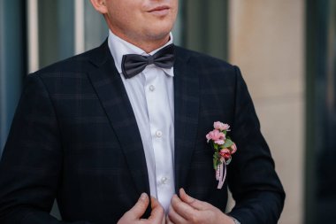 Şık genç adam kol düğmelerinin düğmelerini ilikliyor. Biçim