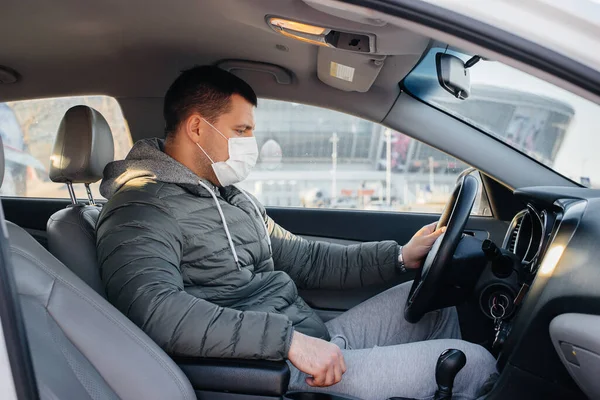 청년이 세계적 유행병과 코로나 바이러스가 유행하는 운전을 하면서 안전을 마스크를 — 스톡 사진