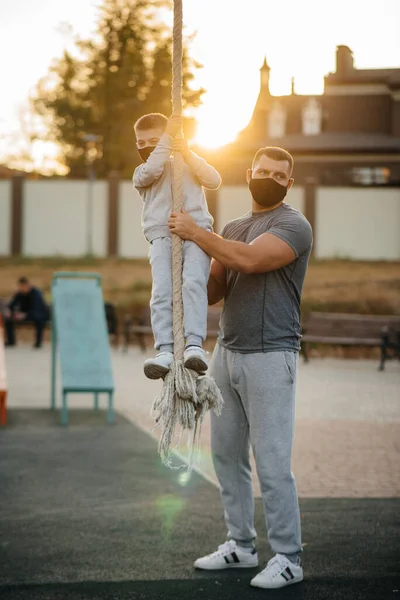 Padre Ayuda Hijo Trepar Una Cuerda Campo Deportes Con Máscaras — Foto de Stock