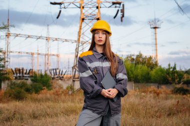Genç bir mühendis, elektrik hattının ekipmanlarını denetleyip kontrol ediyor. Enerji